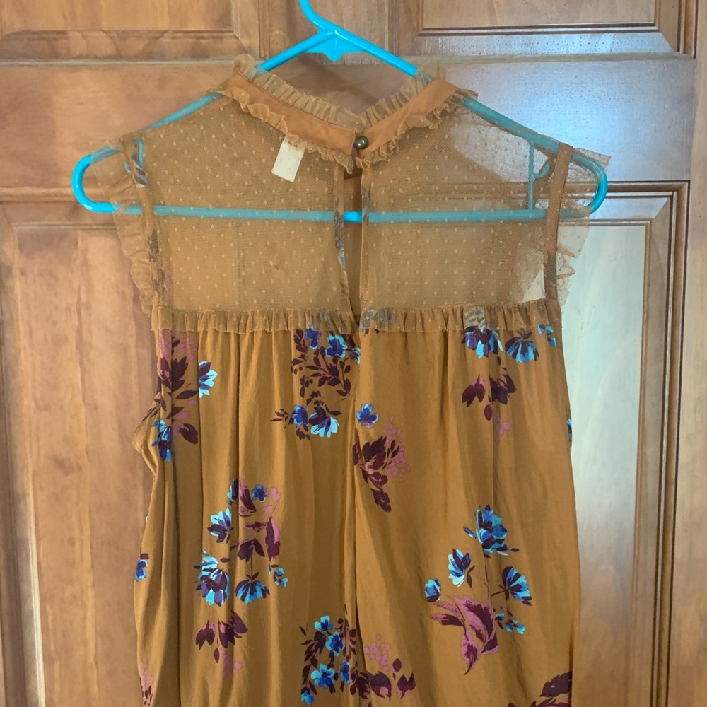 This is a tan floral shirt with a mesh dotted top. The size is XL.